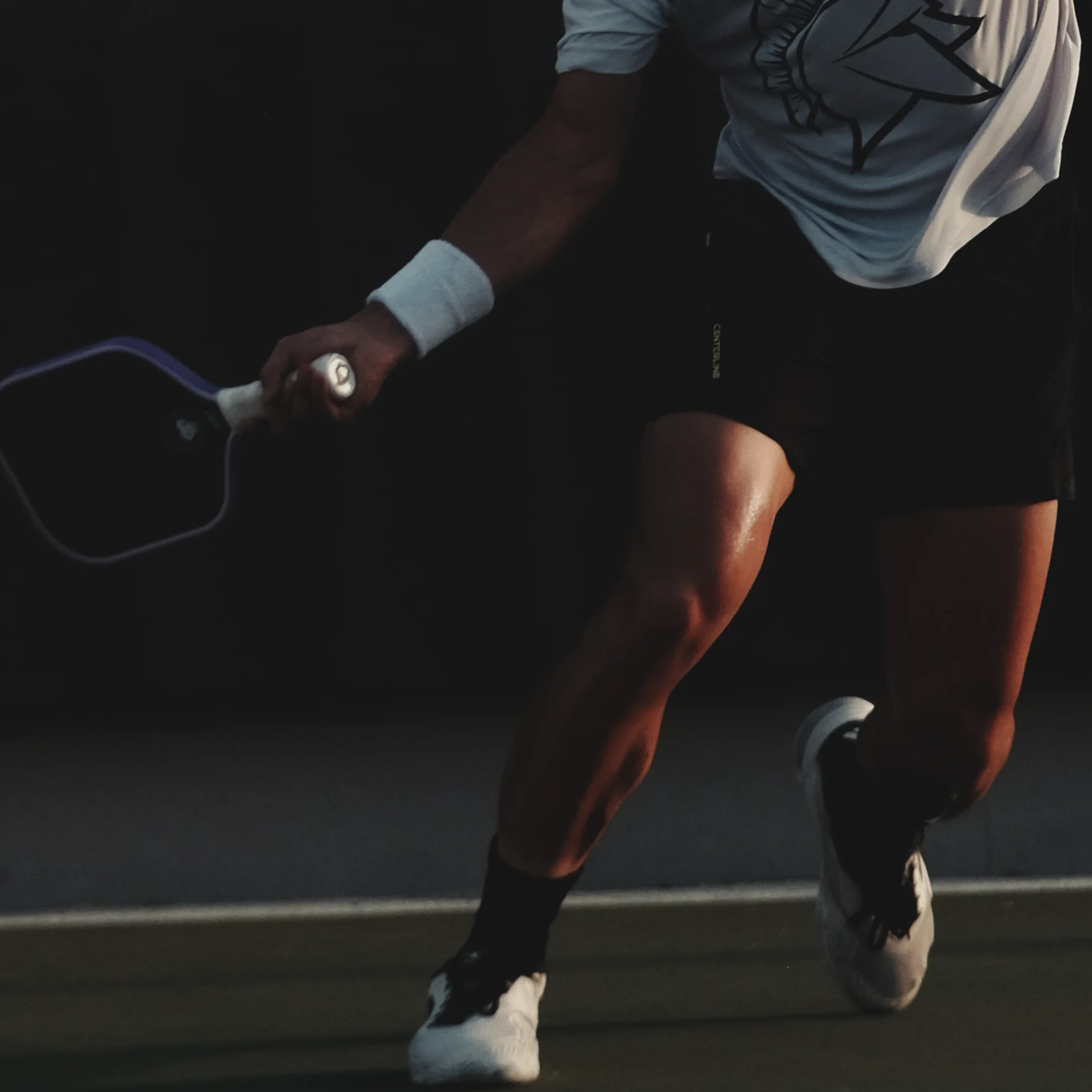 Jugador de pickleball estirándose para alcanzar la pelota